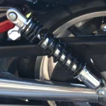 Mechanic inspecting a car shock absorber and suspension component