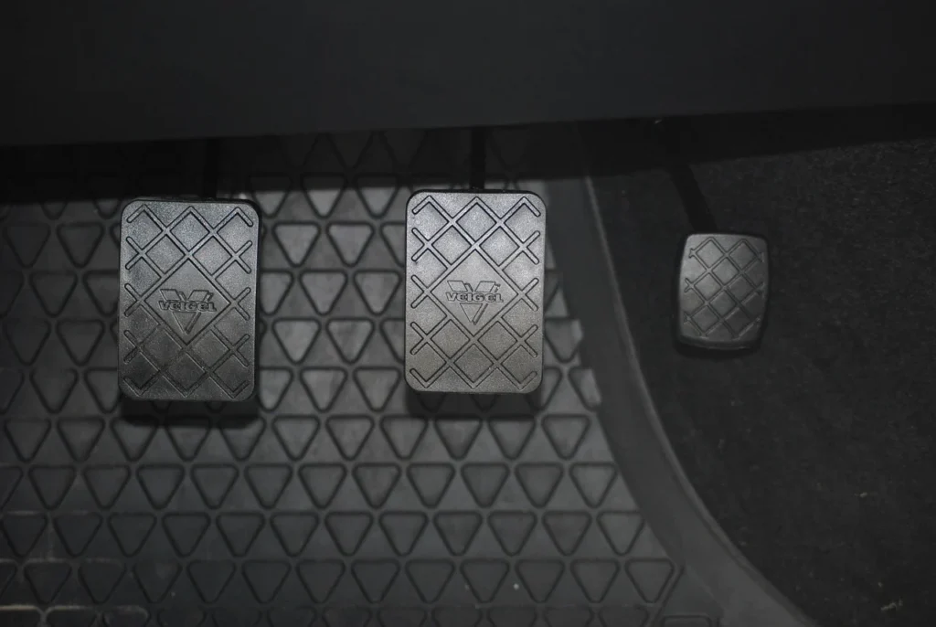 Close-up of a manual car clutch pedal inside the driver footwell