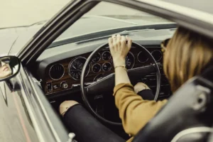 A driver changing gear smoothly with the fuel gauge visible on the dashboard
