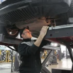 Mechanic inspecting the underside of a car during a pre-purchase check