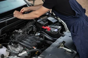 Mobile mechanic technician working on a car outside a customer's home
