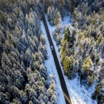 Car navigating a snow dusted road across Baildon Moor in winter