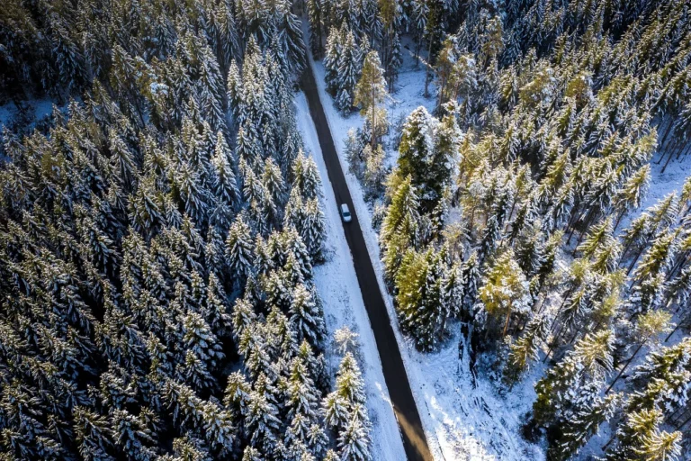 Car navigating a snow dusted road across Baildon Moor in winter