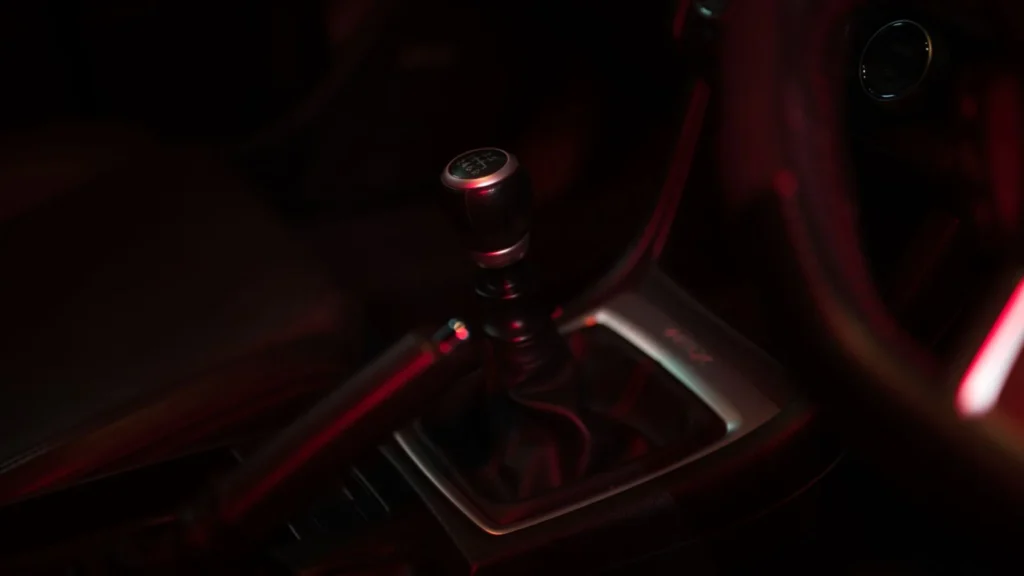 Detailed view of a manual gear shift in a dimly lit car interior, showcasing sleek design — SSK Mechanics guide to Audi A4 Gearbox ID: S Tronic, Multitronic or Manual