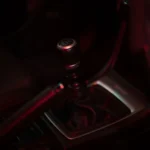 Detailed view of a manual gear shift in a dimly lit car interior, showcasing sleek design — SSK Mechanics guide to Audi A4 Gearbox ID: S Tronic, Multitronic or Manual