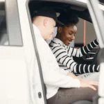 Two adults exploring a car interior at a dealership, smiling and engaged — SSK Mechanics guide to Audi A1 Used-Car Health Checklist