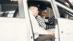 Two adults exploring a car interior at a dealership, smiling and engaged — SSK Mechanics guide to Audi A1 Used-Car Health Checklist