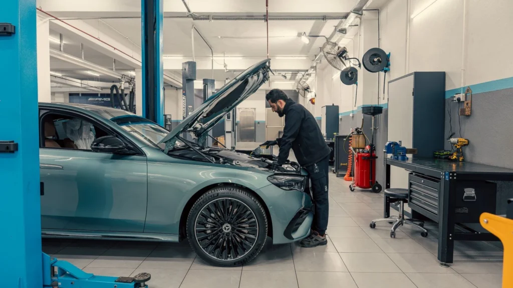 Mechanic inspecting a luxury car inside a well-equipped garage. Vehicle maintenance setting — SSK Mechanics guide to SEAT Ibiza Service and MOT Checklist