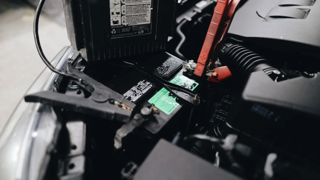 Detailed view of a car battery being jump-started with cables in an engine bay — SSK Mechanics guide to MINI Hatch Battery Check and Car-Not-Starting Guide