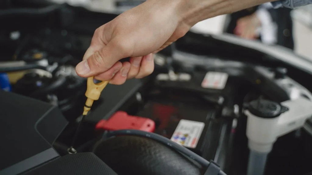 Hand checking oil dipstick in a car engine bay for maintenance and diagnostics — SSK Mechanics guide to Vauxhall Astra Oil Change or Full Service