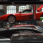 A vibrant red sports car is elevated on a lift inside an auto repair garage, surrounded by… — SSK Mechanics guide to Vauxhall Astra Brake Pads, Discs and Calipers Guide