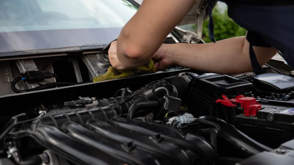 Close-up of a mechanic working on a car engine, showcasing hands and engine details — SSK Mechanics guide to BMW 3 Series Battery Check and Car-Not-Starting Guide