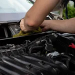 Close-up of a mechanic working on a car engine, showcasing hands and engine details — SSK Mechanics guide to BMW 3 Series Battery Check and Car-Not-Starting Guide