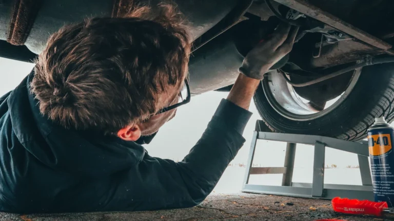Mechanic skillfully repairing car undercarriage in outdoor setting with tools — SSK Mechanics guide to Mercedes A-Class Brake Pads, Discs and Calipers Guide