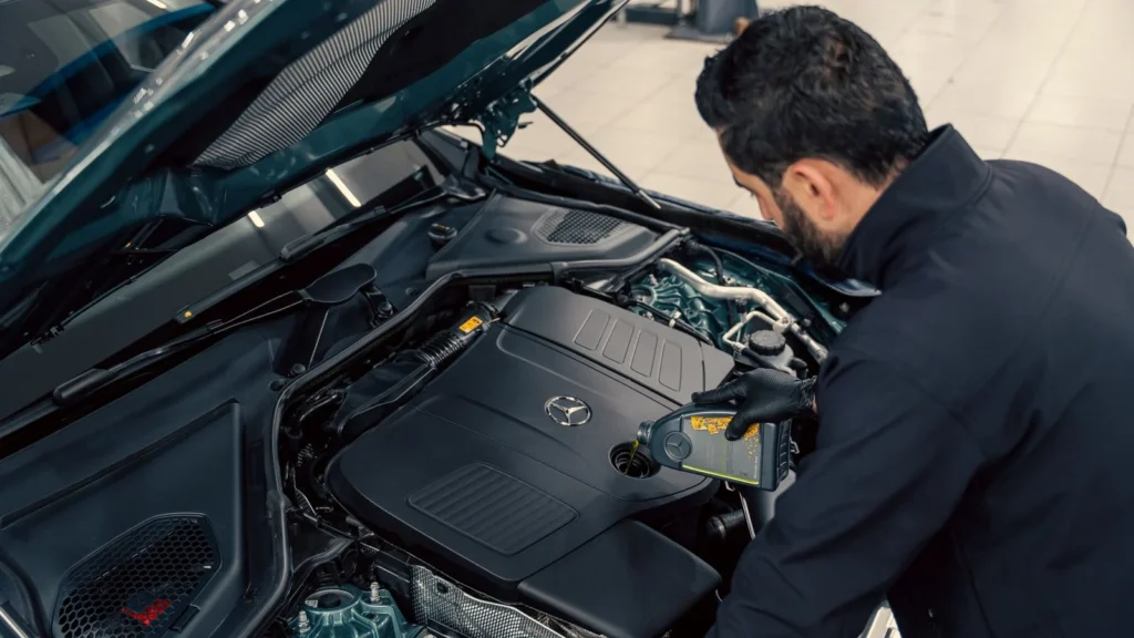Mechanic inspecting and filling engine oil in a car at an indoor service center — SSK Mechanics guide to Ford Kuga Oil Change or Full Service