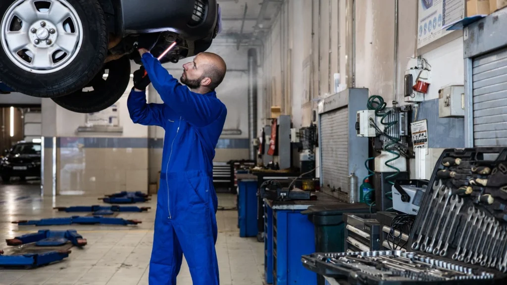 Mechanic inspecting a raised car in an auto workshop for maintenance and repair services — SSK Mechanics guide to Ford Kuga Brake Pads, Discs and Calipers Guide