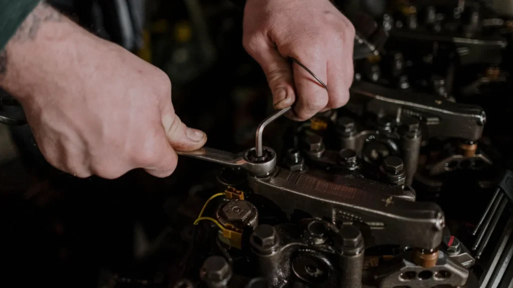 Close-up of a mechanic using a wrench and Allen key to fix an engine — SSK Mechanics guide to Mercedes C-Class Oil Change or Full Service