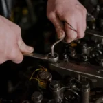 Close-up of a mechanic using a wrench and Allen key to fix an engine — SSK Mechanics guide to Mercedes C-Class Oil Change or Full Service