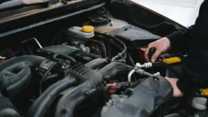 Close-up of a mechanic's hands working on a car engine, showcasing repair work — SSK Mechanics guide to Renault Clio Battery Check and Car-Not-Starting Guide