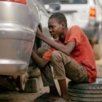 Young mechanic focused on repairing a car tire in an outdoor garage — SSK Mechanics guide to Vauxhall Mokka Brake Pads, Discs and Calipers Guide