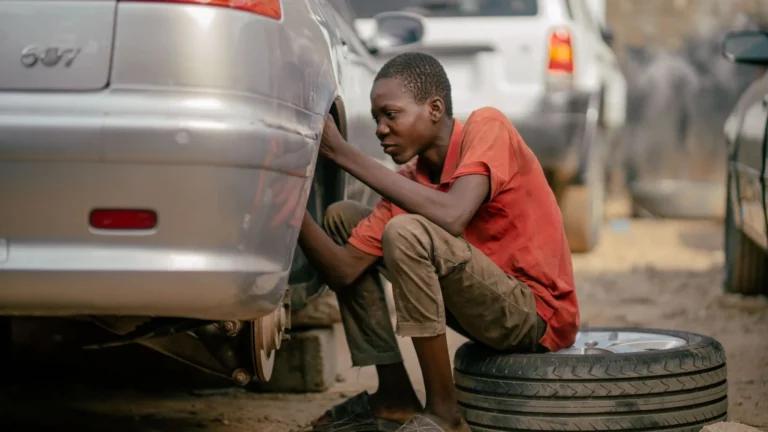 Young mechanic focused on repairing a car tire in an outdoor garage — SSK Mechanics guide to Vauxhall Mokka Brake Pads, Discs and Calipers Guide