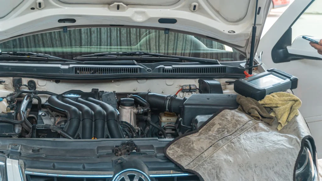 Close-up of a Volkswagen car engine undergoing repair in a garage, tools and diagnostic… — SSK Mechanics guide to Toyota Aygo Battery Check and Car-Not-Starting Guide