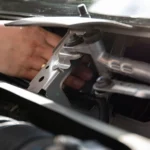 Mechanic's hand repairing car wiper mechanism in detailed close-up — SSK Mechanics guide to Hyundai i10 Wipers, Bulbs and Fuse Changes