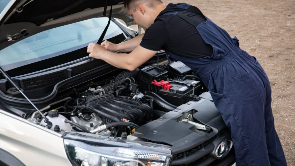 Mechanic working on a car engine with hood open, showcasing automotive repair skills — SSK Mechanics guide to Peugeot 208 Battery Check and Car-Not-Starting Guide