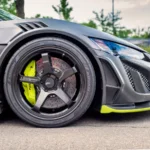 Detailed view of a sleek sports car wheel in a parking lot, showcasing performance tires and… — SSK Mechanics guide to Ford Puma Brake Pads, Discs and Calipers Guide