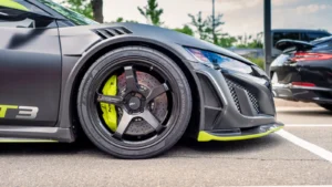 Detailed view of a sleek sports car wheel in a parking lot, showcasing performance tires and… — SSK Mechanics guide to Ford Puma Brake Pads, Discs and Calipers Guide