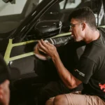 Technician polishing car paint during a scratch repair assessment