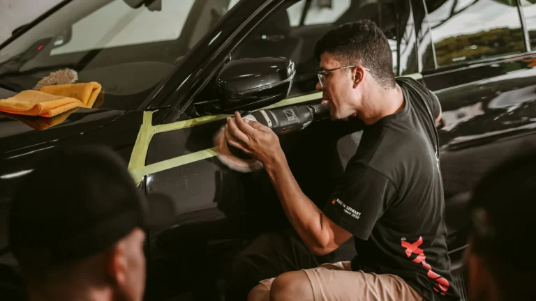 Technician polishing car paint during a scratch repair assessment