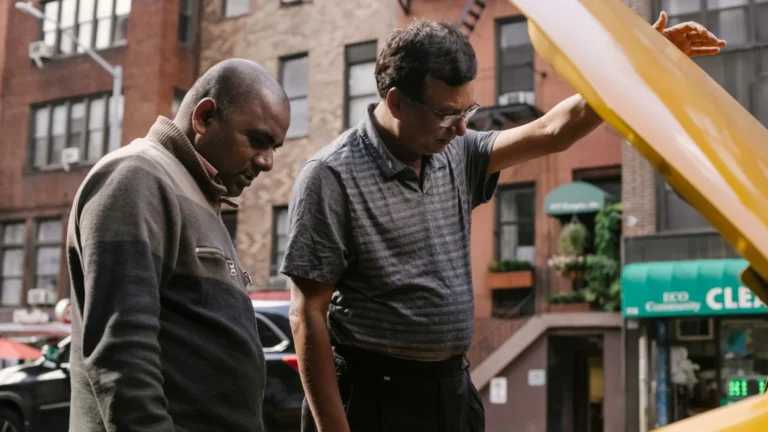 Ethnic males having problem in motor under hood of car on city street — SSK Mechanics guide to Why Does My Car Keep Stalling at Junctions