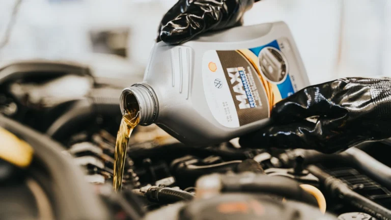 Close-up of a mechanic pouring engine oil into a car engine, highlighting maintenance work — SSK Mechanics guide to Oil Leak Under the Car: What Could Be Causing It