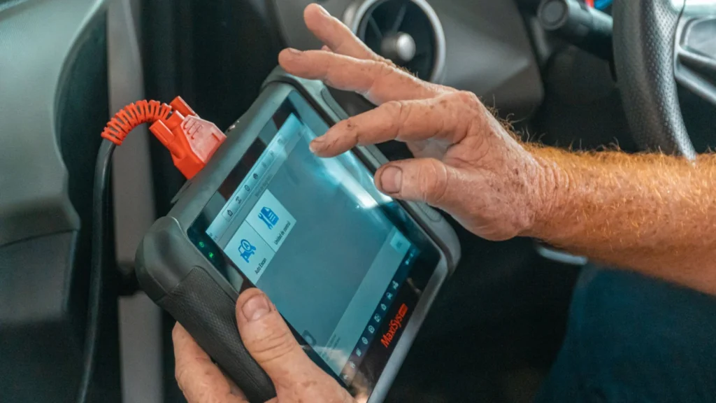 Mechanic using a diagnostic tool inside a car to check for engine issues and ensure proper… — SSK Mechanics guide to Why Has My Car Lost Power or Feels Sluggish to Accelerate