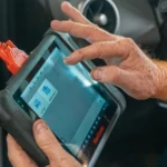 Mechanic using a diagnostic tool inside a car to check for engine issues and ensure proper… — SSK Mechanics guide to Why Has My Car Lost Power or Feels Sluggish to Accelerate