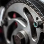 Closeup of black thin timing belt on round metallic camshaft sprocket in daylight on blurred… — SSK Mechanics guide to Cambelt (Timing Belt) Replacement Cost: Why Timing Matters…