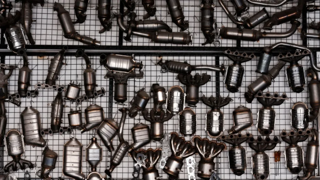 An array of automotive exhaust parts displayed on a grid wall in an industrial garage setting — SSK Mechanics guide to DPF Cleaning Cost vs Replacement: How to Tell Which One You Need