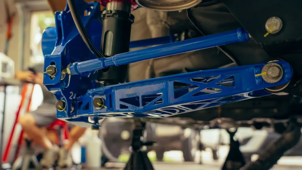 Detailed view of a blue custom car suspension part in an auto garage — SSK Mechanics guide to Tie Rod End Replacement Cost: Why It's Rarely Sold on Its Own