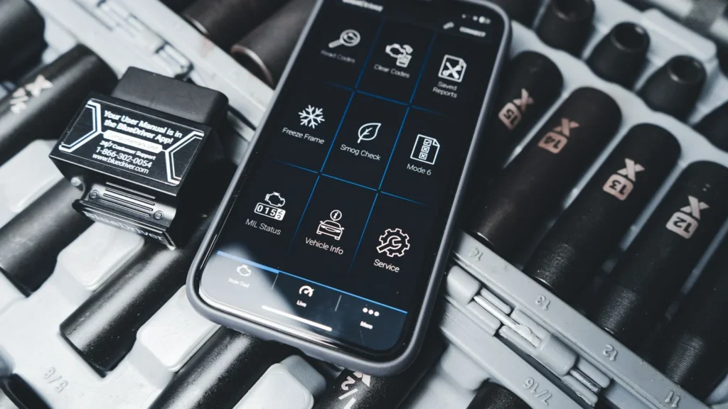 Close-up of a smartphone showing car diagnostic app with OBD2 scanner in a garage setting — SSK Mechanics guide to Check Engine Light On? Here's What It Actually Means