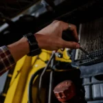 Close-up of a mechanic's hand using a screwdriver to inspect a vehicle's engine — SSK Mechanics guide to Coolant Temperature Warning Light: What It Means and What to…