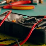 Close-up view of a multimeter and various tools on a workspace table — SSK Mechanics guide to Battery Warning Light On: What It Means and How Urgent It Is