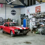 A vintage red car undergoing restoration in a well-equipped workshop with various tools and auto… — SSK Mechanics guide to The Most Common MOT Fail Reasons (and How to Avoid Them)
