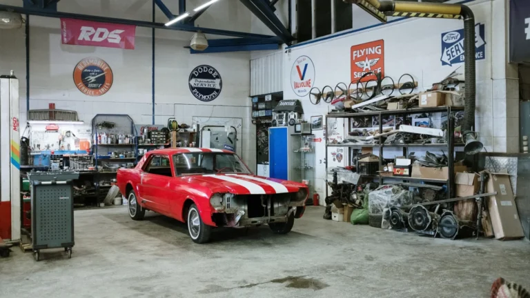 A vintage red car undergoing restoration in a well-equipped workshop with various tools and auto… — SSK Mechanics guide to The Most Common MOT Fail Reasons (and How to Avoid Them)
