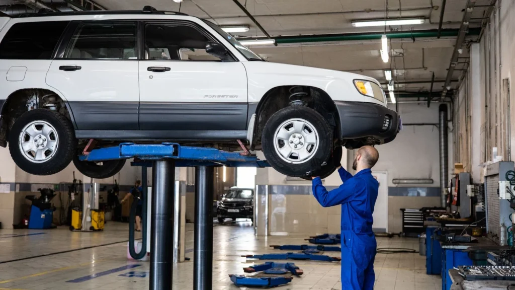 A mechanic inspecting a white SUV lifted in a well-lit auto repair shop — SSK Mechanics guide to Hybrid Car MOT: What's Different From a Petrol or Diesel Test