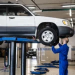 A mechanic inspecting a white SUV lifted in a well-lit auto repair shop — SSK Mechanics guide to Hybrid Car MOT: What's Different From a Petrol or Diesel Test