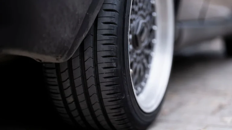 Detailed view of a car tire on urban pavement, showcasing tread and wheel design — SSK Mechanics guide to Your Pre-Long-Journey Car Checklist