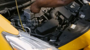 Driver carrying out an under-bonnet maintenance check outdoors — SSK Mechanics guide to extending the life of your car