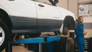 Mechanic evaluating a car on a lift for maintenance in an auto workshop — SSK Mechanics guide to Do Electric and Hybrid Cars Still Need Brake Fluid Changes