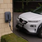 A white electric car charging at a station in Christchurch, New Zealand, showcasing modern… — SSK Mechanics guide to Home Charging vs Public Charging: What Actually Differs